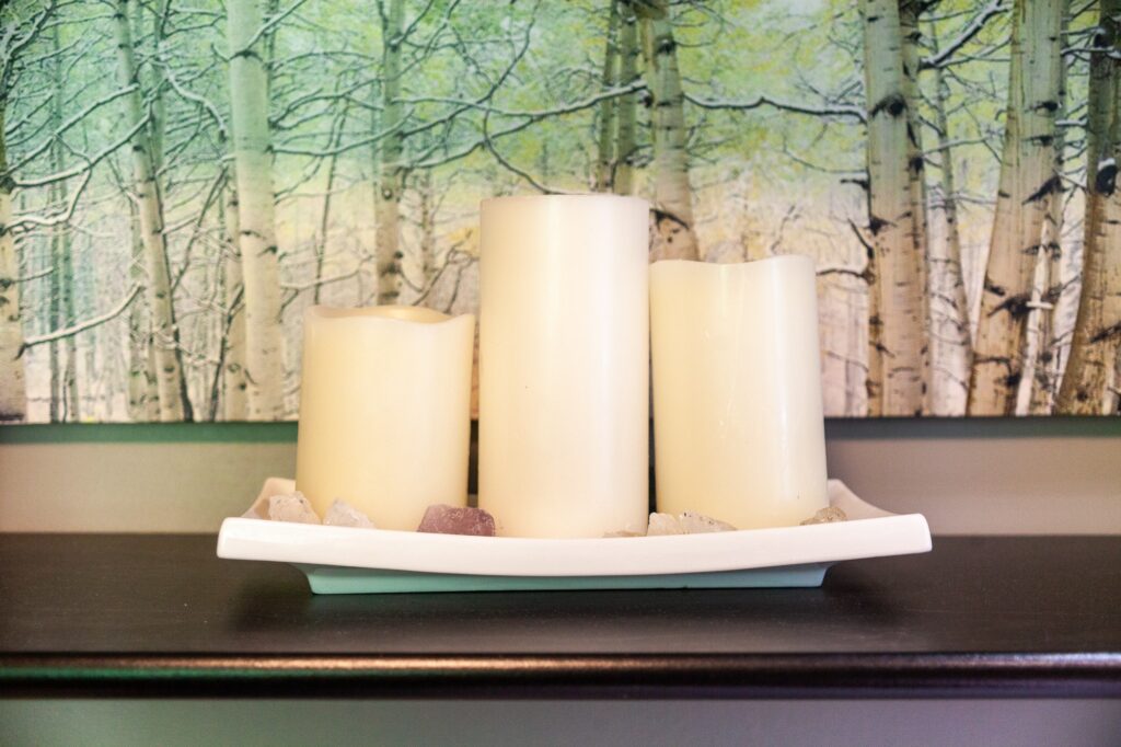 Decorative candles with birch tree wallpaper creating calming spa ambiance at Trillium Resort and Spa Muskoka Huntsville Port Sydney