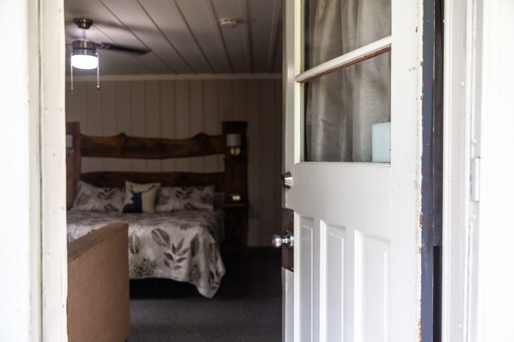 Cozy cottage bedroom with dark wood bed frame and warm lighting at Trillium Resort and Spa Muskoka Huntsville Port Sydney