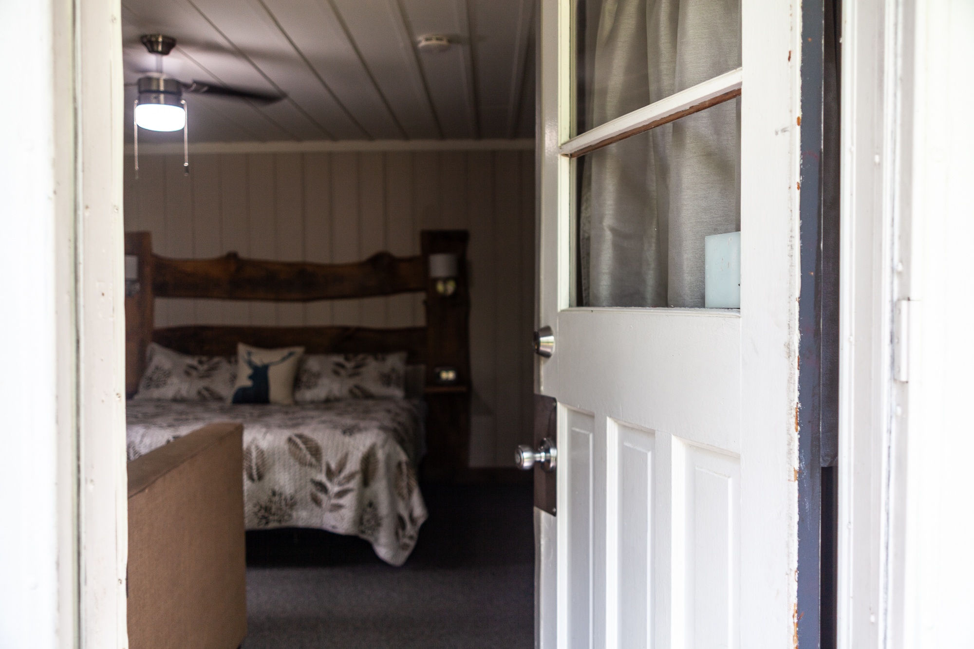 Cozy cottage bedroom with dark wood bed frame and warm lighting at Trillium Resort and Spa Muskoka Huntsville Port Sydney