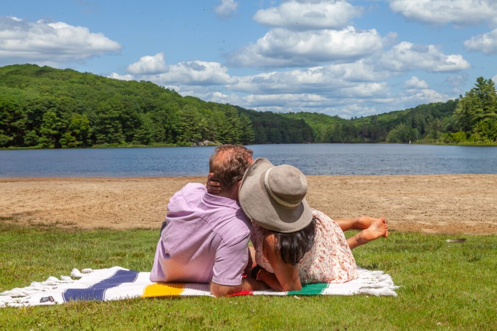 Couple relaxing on blanket overlooking blue Muskoka lake at Trillium Resort and Spa romantic couples retreat Huntsville Port Sydney