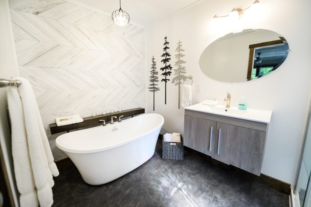 Spa-inspired ensuite with freestanding tub dual vanity and herringbone tile in Rushing Water cottage at Trillium Resort Muskoka Huntsville