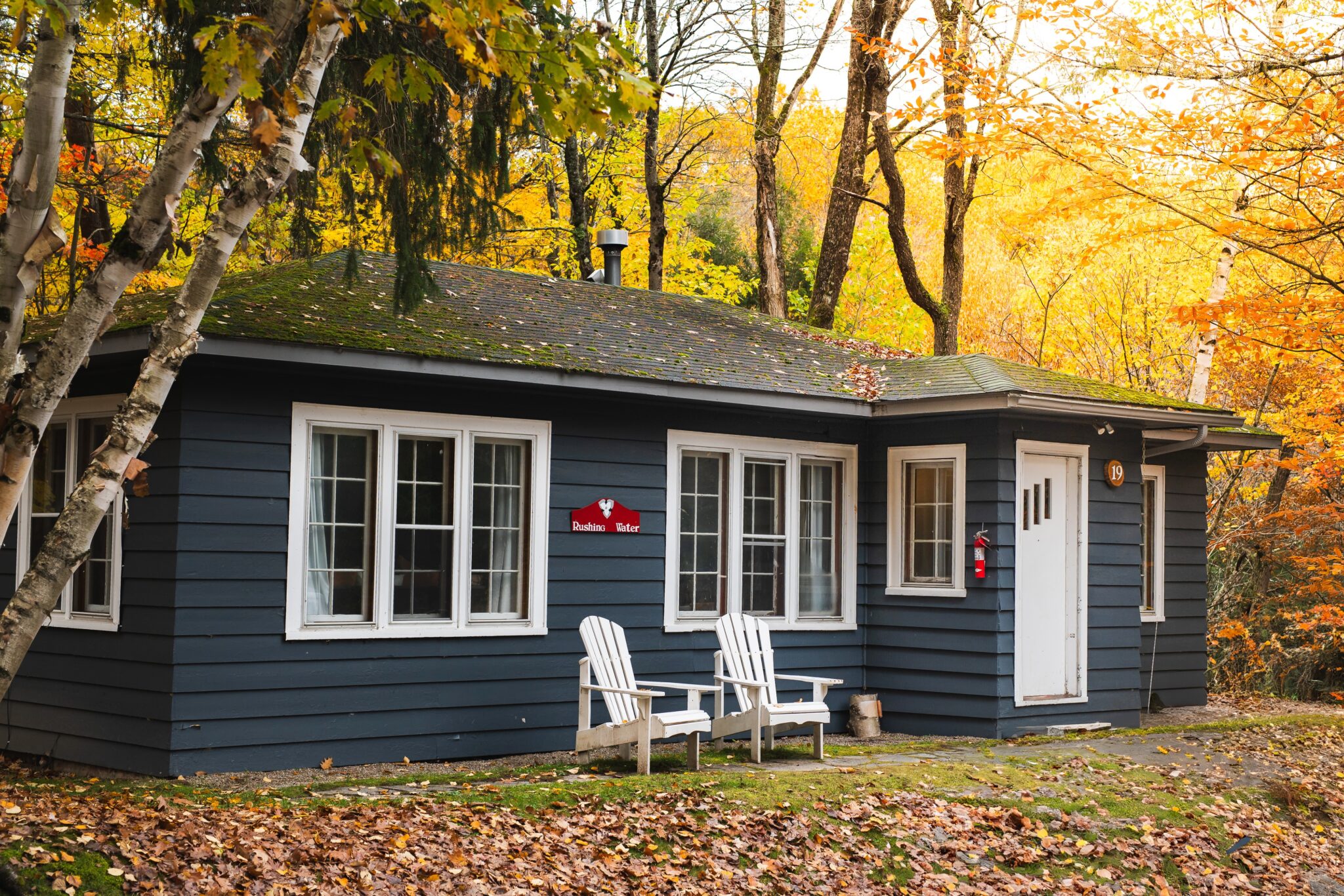 Rushing Water private suite exterior surrounded by vibrant golden autumn foliage at Trillium Resort and Spa Muskoka Port Sydney
