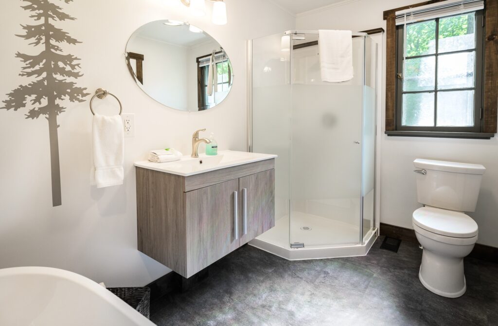 Modern bathroom with frameless glass shower and forest-inspired decor in Falling Water cottage at Trillium Resort and Spa Muskoka Huntsville