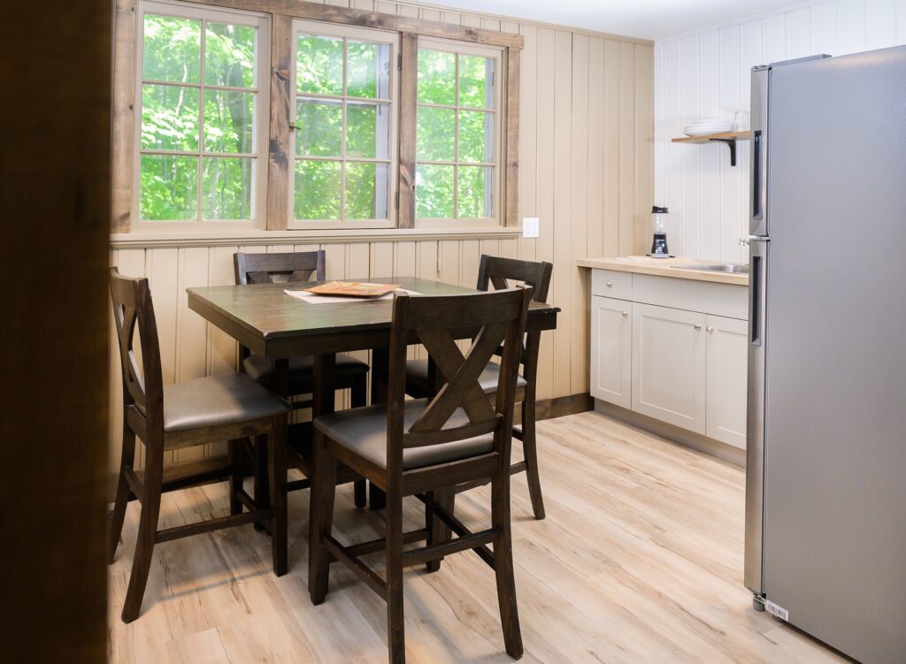 Sunny kitchenette and dining nook overlooking Muskoka forest in Falling Water cottage at Trillium Resort and Spa Huntsville