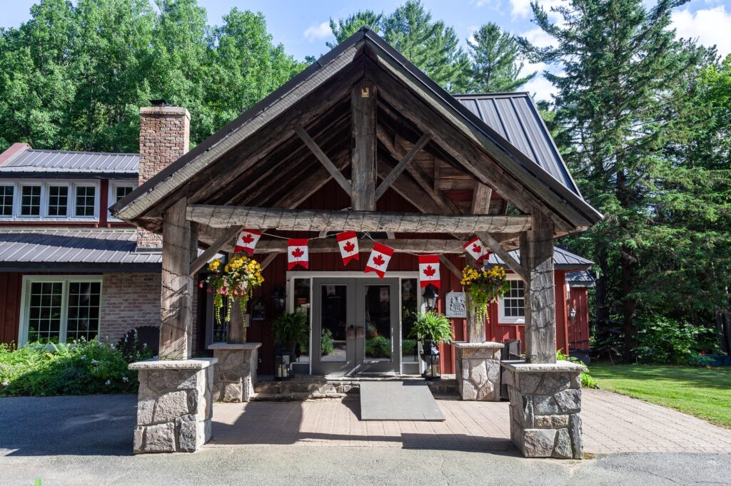 Trillium Resort and Spa main lodge entrance featuring post-and-beam timber architecture with Canadian flags Muskoka Port Sydney Huntsville