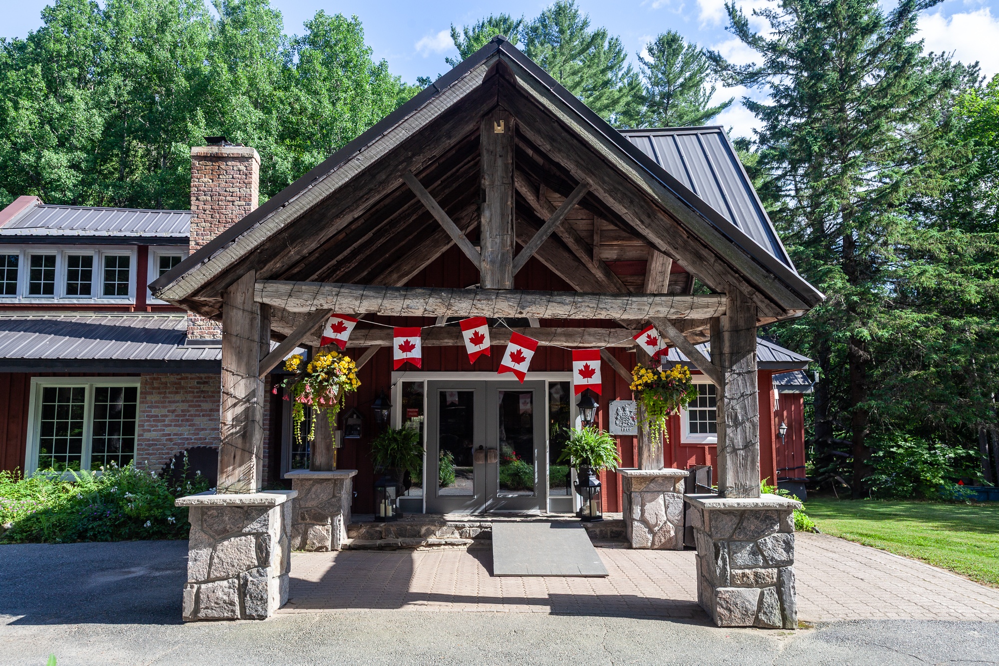 Trillium Resort and Spa main lodge entrance featuring post-and-beam timber architecture with Canadian flags Muskoka Port Sydney Huntsville