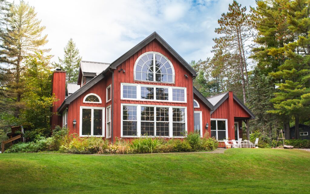 Trillium Resort and Spa red barn-style main lodge with white trim surrounded by spring foliage Muskoka Huntsville Port Sydney