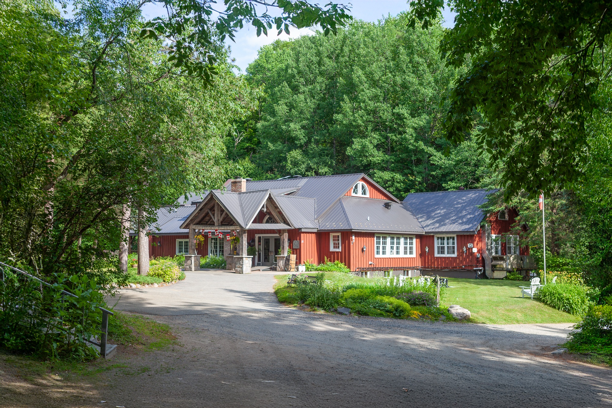 Trillium Resort and Spa main lodge with red timber architecture surrounded by green trees in summer in Huntsville Muskoka Port Sydney