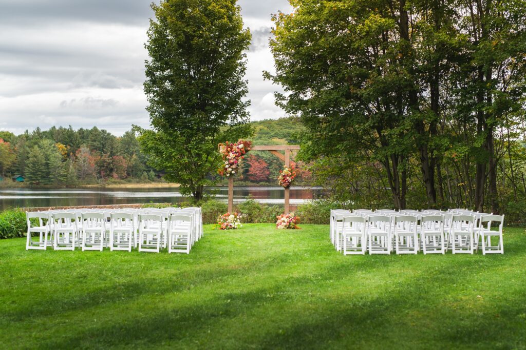 Lakeside outdoor wedding ceremony setup with white chairs and floral arrangements at Trillium Resort and Spa Muskoka Huntsville Port Sydney
