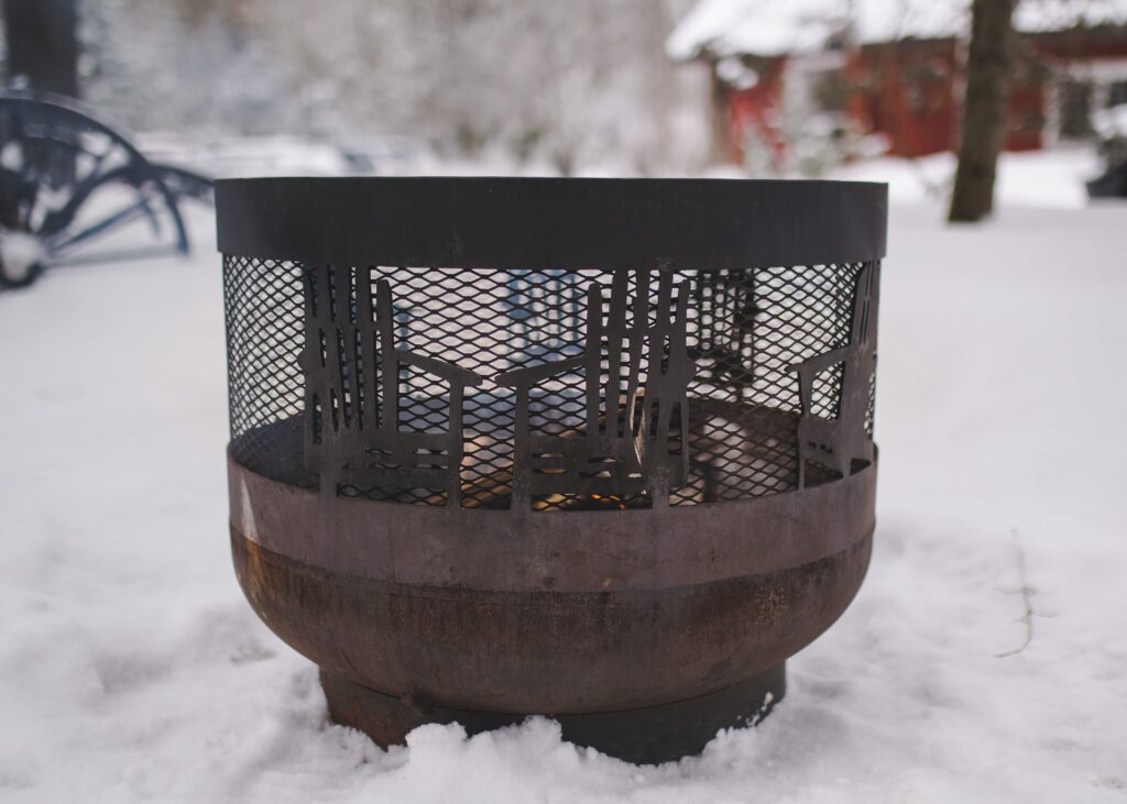 Outdoor firepit glowing on snowy grounds at Trillium Resort and Spa in winter Muskoka Huntsville Port Sydney
