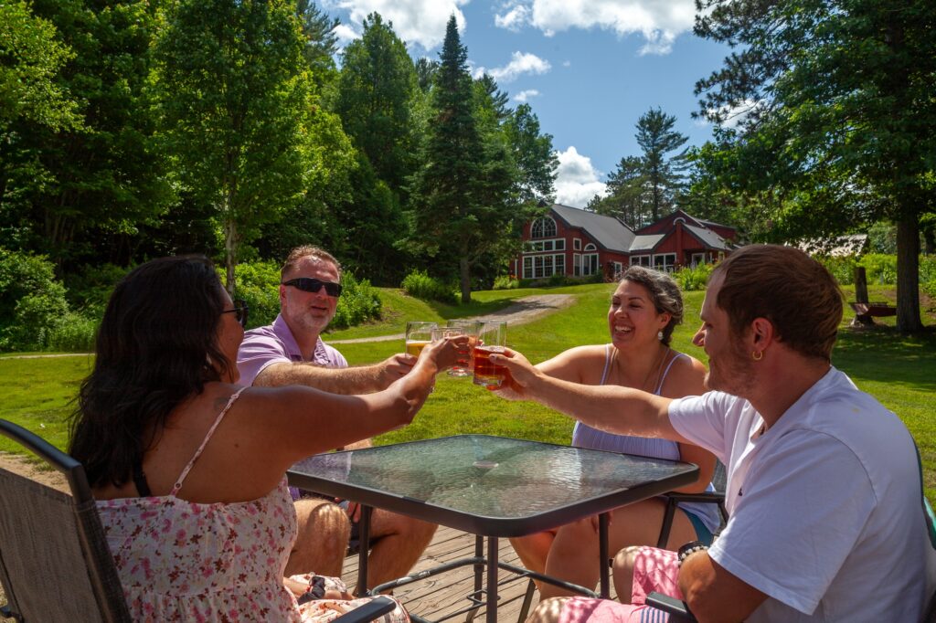 Friends toasting on sunny outdoor patio at Trillium Resort and Spa in summer Muskoka Huntsville Port Sydney