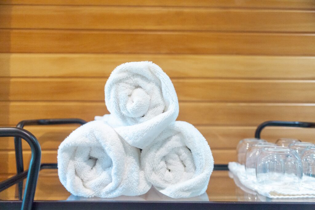 Rolled white spa towels arranged beside sauna at Trillium Resort and Spa wellness centre Muskoka Port Sydney Huntsville
