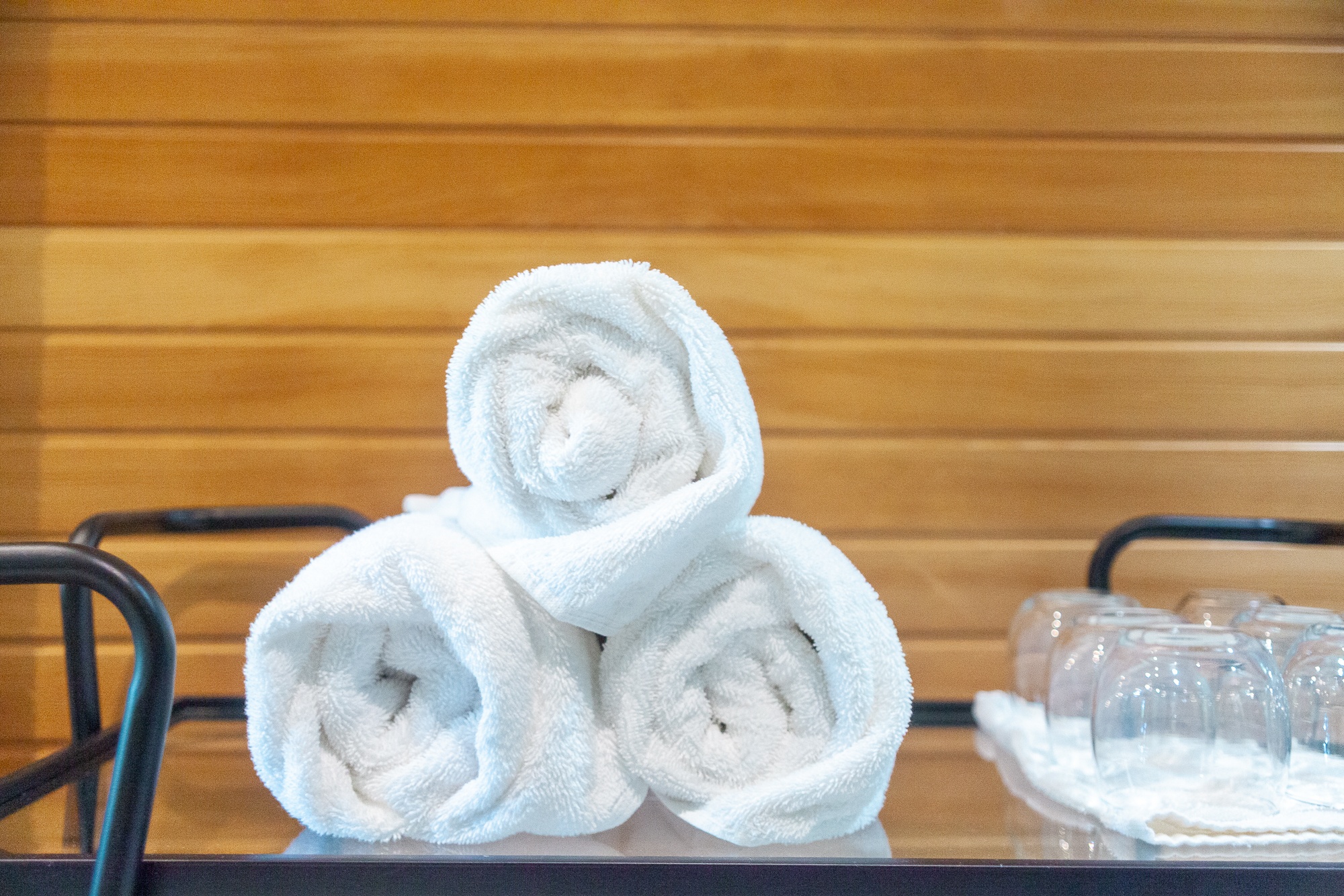 Rolled white spa towels arranged beside sauna at Trillium Resort and Spa wellness centre Muskoka Port Sydney Huntsville