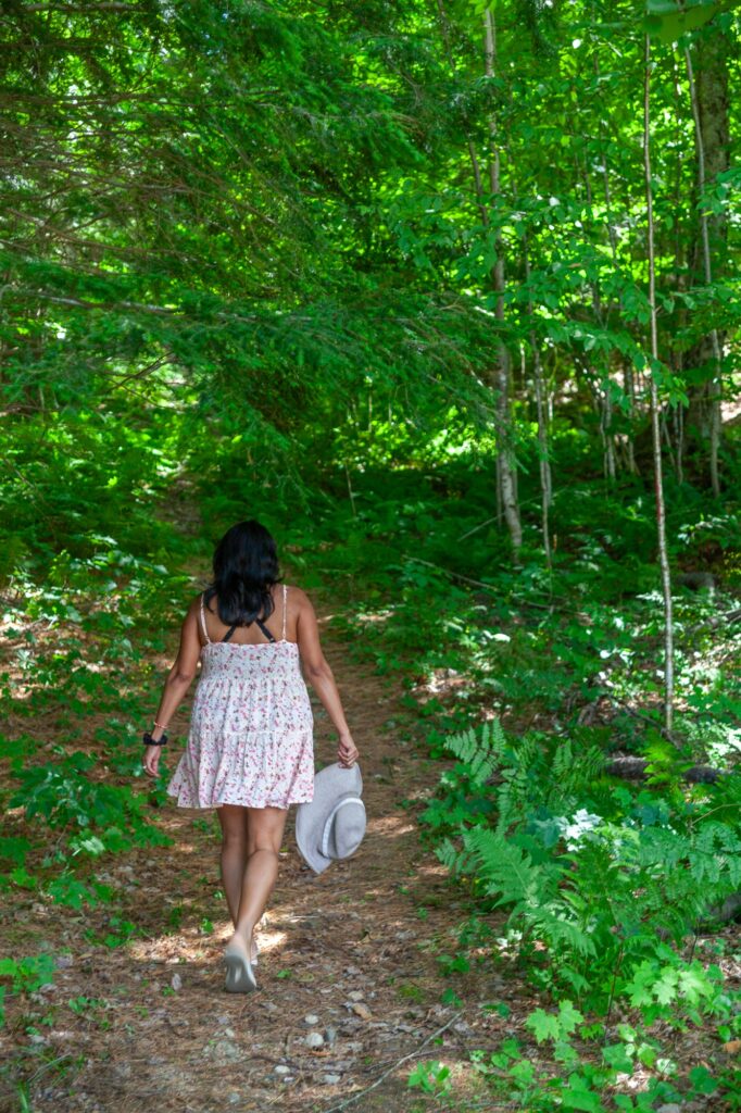 Woman walking along a peaceful forest hiking trail in summer near Trillium Resort and Spa Muskoka Huntsville Port Sydney